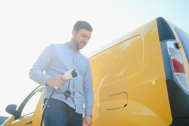 Hombre cargando su coche eléctrico en la estación de carga