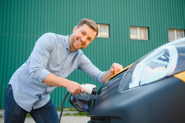 Hombre cargando su coche eléctrico en la estación de carga