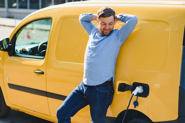 Hombre cargando vehículo eléctrico con cable