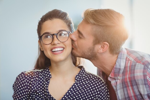 Hombre cariñoso besando a mujer