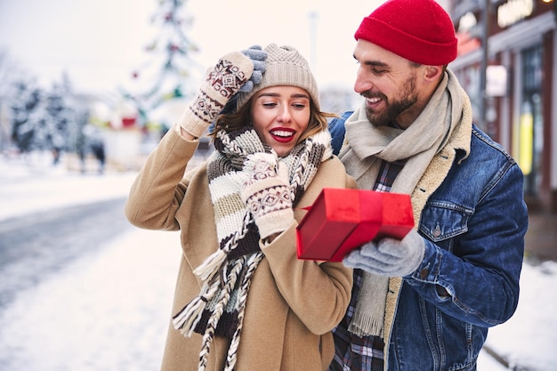 Hombre cariñoso haciendo regalo para novia al aire libre