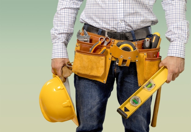 Hombre carpintero cinturón de herramientas nivel casco en blanco