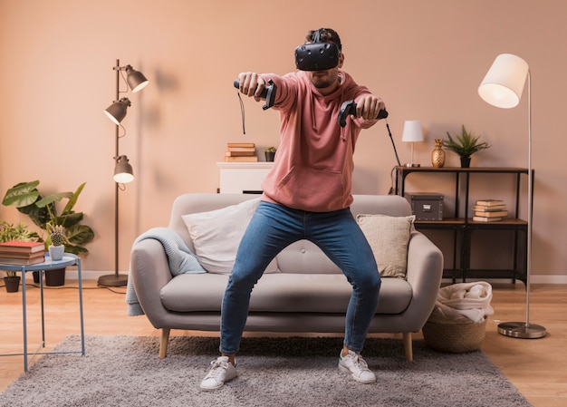 Foto hombre en casa jugando con auriculares virtuales