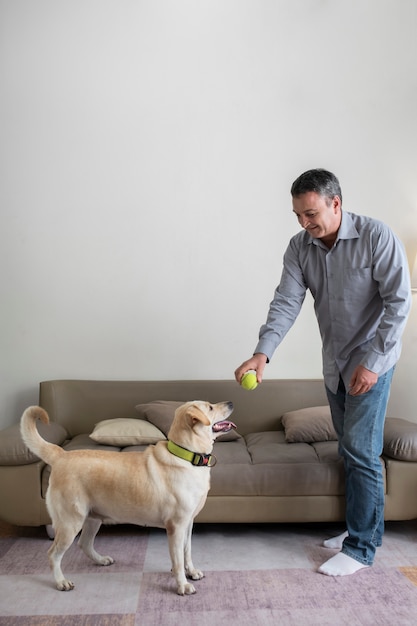 Foto hombre en casa con su compañero de perro