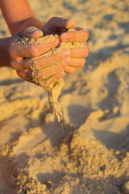 Hombre casado con arena en las manos. Hora del atardecer