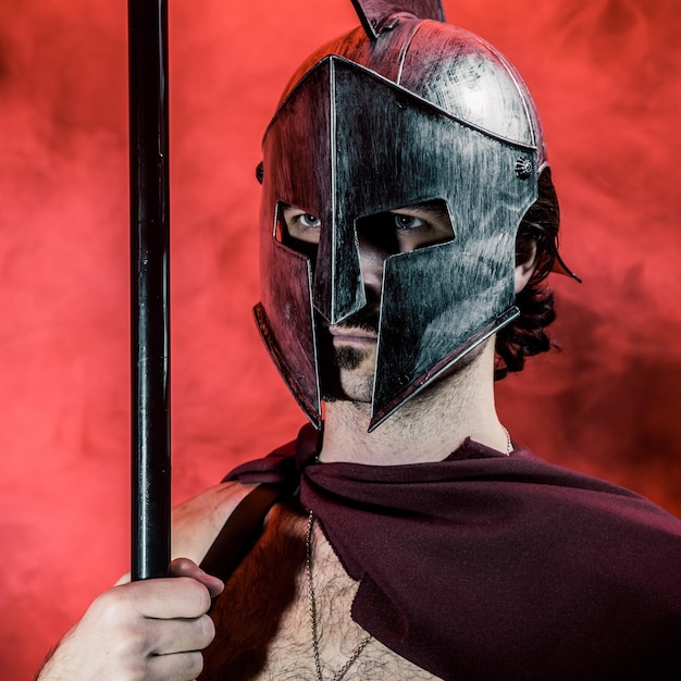 Foto hombre con casco blindado en el cuarto oscuro