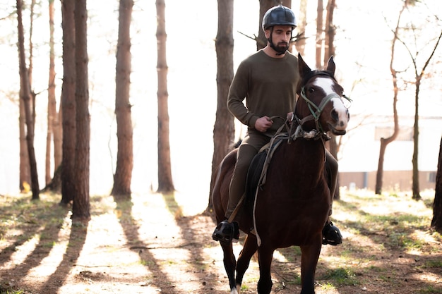 Hombre con casco a caballo en el bosque