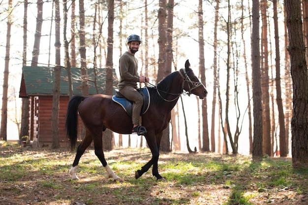 Hombre con casco a caballo en el bosque