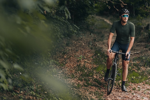 Hombre con casco y gafas practicando ciclismo al aire libre