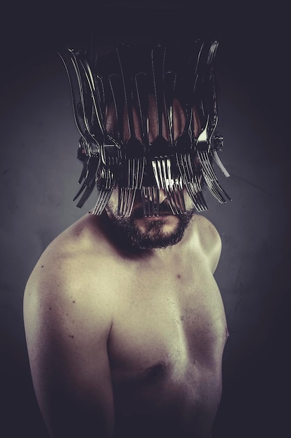 Hombre con casco hecho de tenedores y cuchillos, concepto