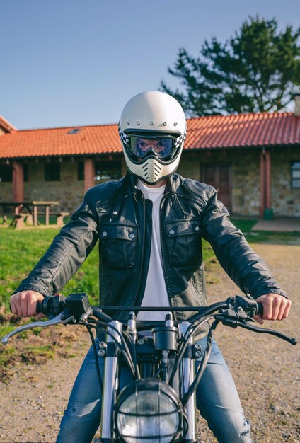 Hombre con casco montando moto custom