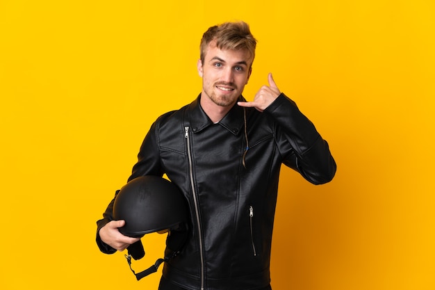 Hombre con un casco de moto aislado haciendo gesto de teléfono