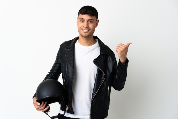 Hombre con un casco de motocicleta aislado en blanco apuntando hacia el lado para presentar un producto