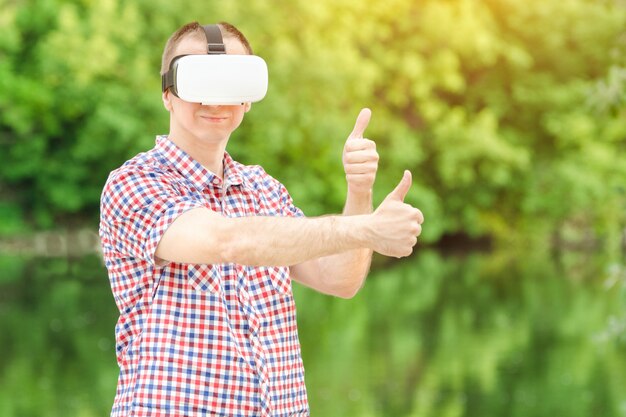 Hombre en un casco de realidad virtual en el contexto de la naturaleza.