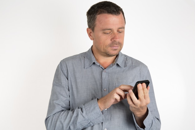 Foto hombre casual y encantador haciendo un sms aislado en blanco
