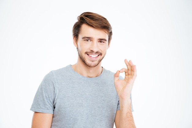 Hombre casual feliz mostrando signo ok con los dedos aislado sobre un fondo blanco.