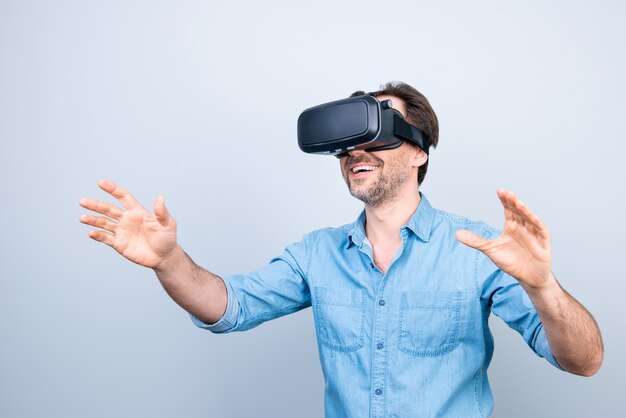 Hombre casual sonriente con casco de realidad virtual