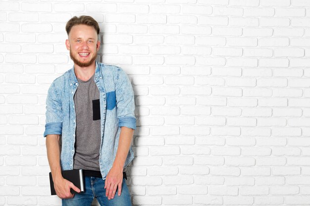 Foto hombre casual sonriente y pensativo que lee un libro