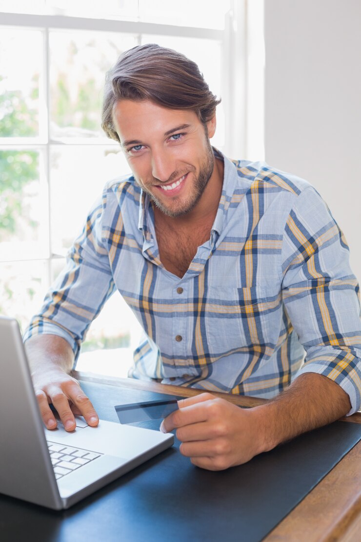 Foto hombre casual sonriente que usa la computadora portátil para comprar en línea