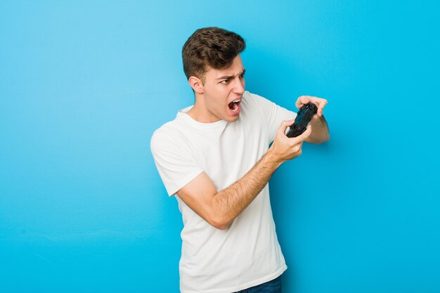 Hombre caucásico adolescente usando un controlador de juego