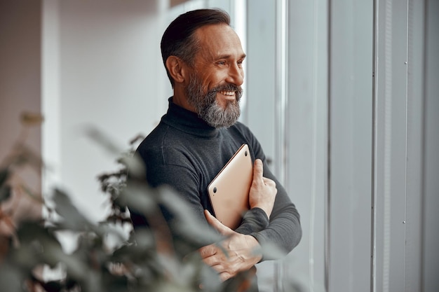 Hombre caucásico adulto feliz de pie en una oficina moderna