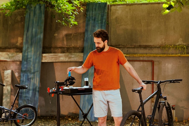 Hombre caucásico amante de los deportes que selecciona herramientas especializadas para el mantenimiento de bicicletas en el patio de su casa. Ciclista masculino sano y activo revisando su kit de herramientas para equipo profesional para reparar bicicletas.