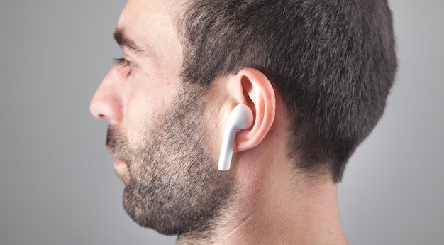 Hombre caucásico con auriculares inalámbricos blancos.