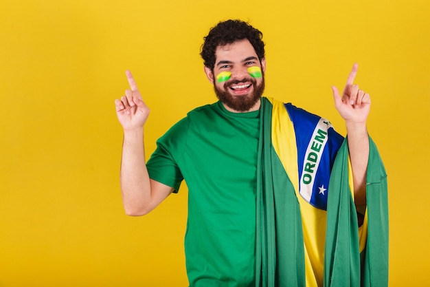 Foto hombre caucásico con barba fanático del fútbol brasileño de brasil bailando y festejando haciendo poco