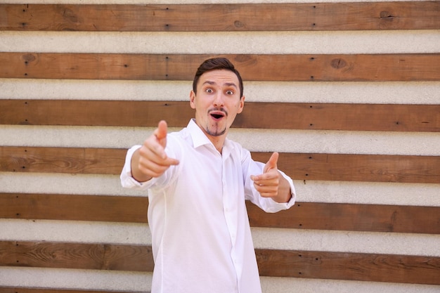 Un hombre caucásico barbudo realmente sorprendido con una camisa blanca con la boca abierta