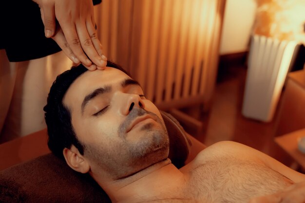Hombre caucásico disfrutando de un relajante masaje de cabeza contra el estrés tranquilo