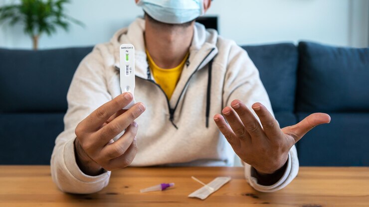Foto hombre caucásico fabrica un dispositivo de prueba rápido en el hogar para el virus covid19 con un resultado positivo cassette de antígeno de la prueba pcr express para la nueva variante del virus omicron