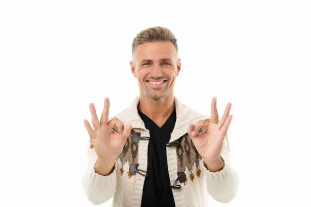 El hombre caucásico feliz en la rebeca muestra los gestos del anillo doble OK aislados en blanco, está bien.