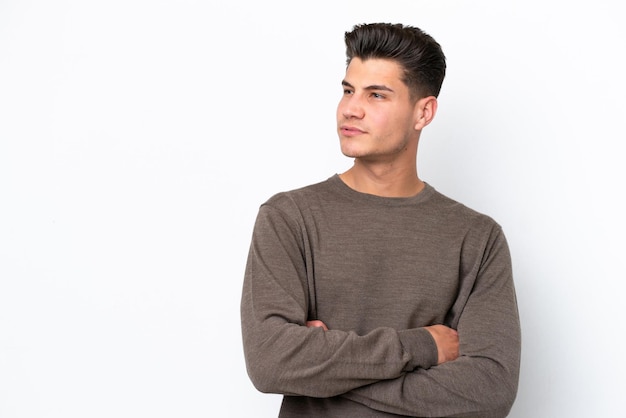 Hombre caucásico guapo joven aislado en bakcground blanco mirando hacia el lado