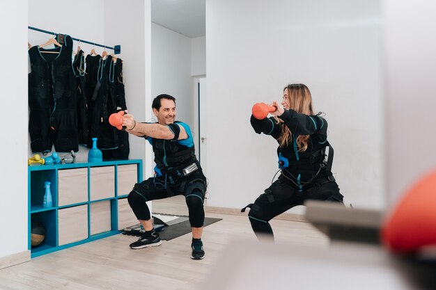 Hombre caucásico haciendo flexiones con una cuerda mientras usa una electroestimulación