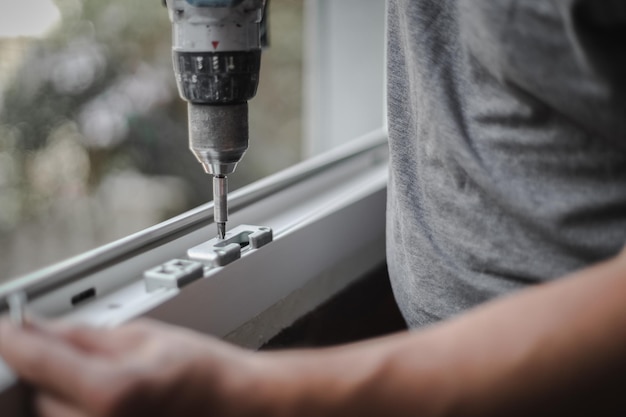 Hombre caucásico instala accesorios para un marco de ventana