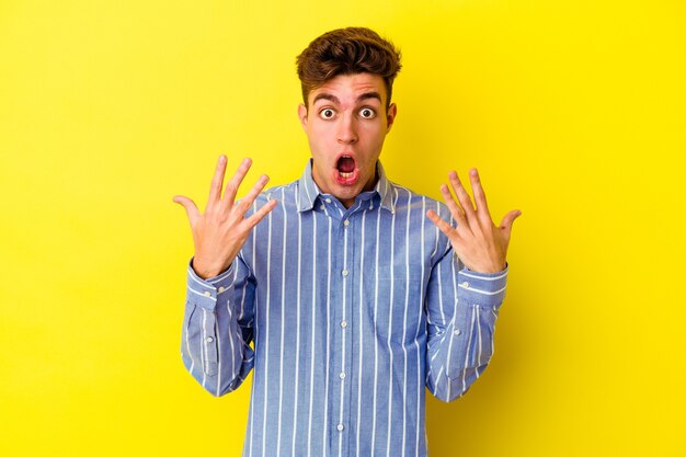 Hombre caucásico joven aislado en la pared amarilla que muestra el número diez con las manos.