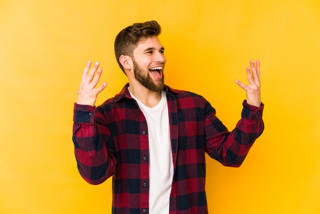 Hombre caucásico joven aislado en la pared amarilla riendo alegremente mucho. Concepto de felicidad.