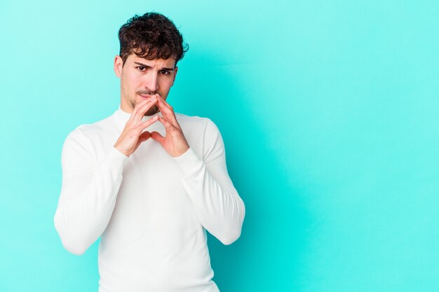 Foto hombre caucásico joven aislado en la pared azul haciendo un plan en mente, creando una idea.