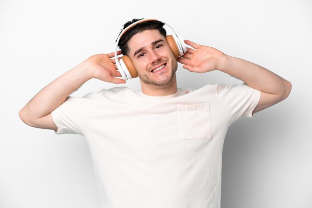 Hombre caucásico joven aislado sobre fondo blanco escuchando música