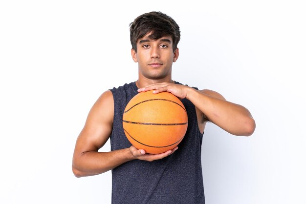 Hombre caucásico joven aislado sobre fondo blanco jugando baloncesto