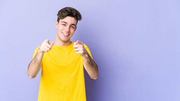 Hombre caucásico joven apuntando al frente con los dedos.