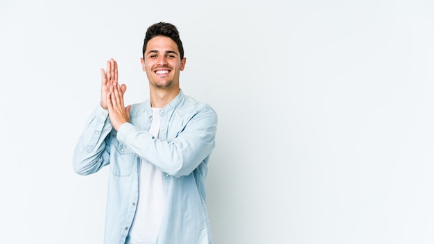 Foto hombre caucásico joven en blanco sintiéndose enérgico y cómodo, frotándose las manos confiado.