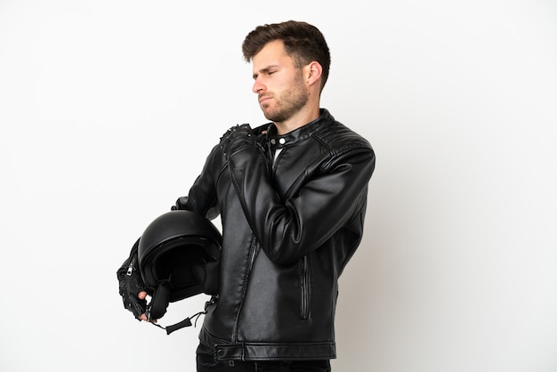 Hombre caucásico joven con un casco de moto aislado sobre fondo blanco que sufre de dolor en el hombro por haber hecho un esfuerzo
