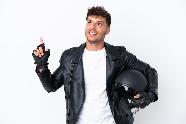 Hombre caucásico joven con un casco de motocicleta aislado sobre fondo blanco apuntando hacia una gran idea