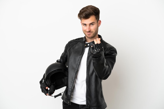 Hombre caucásico joven con un casco de motocicleta aislado sobre fondo blanco haciendo gesto de dinero