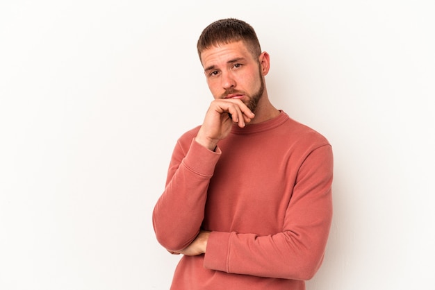 Hombre caucásico joven con diastema aislado sobre fondo blanco cansado de una tarea repetitiva.