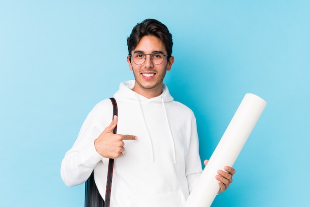 Hombre caucásico joven estudiando arquitectura persona aislada apuntando con la mano a una camisa copia espacio, orgulloso y confiado