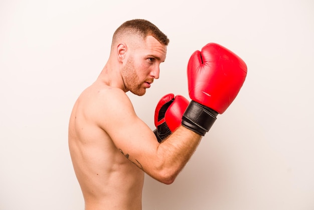 Hombre caucásico joven haciendo boxeo aislado sobre fondo blanco.