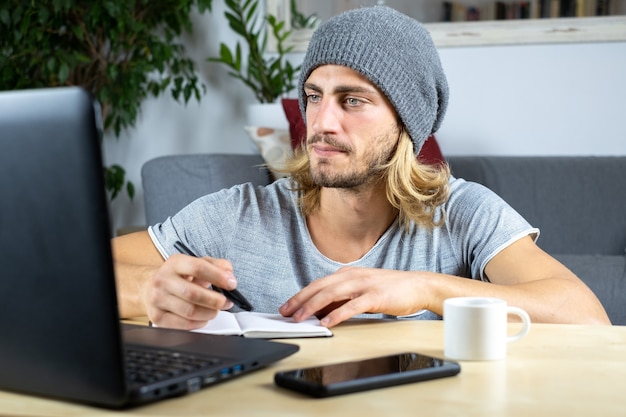 Hombre caucásico joven hermoso que trabaja en casa