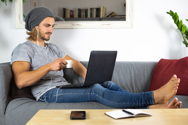 Hombre caucásico joven hermoso que trabaja en casa